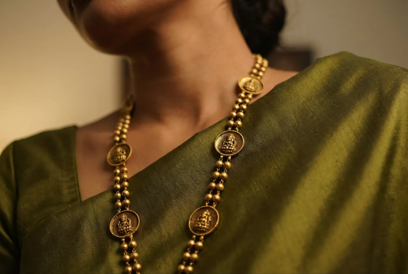 Temple gold mango pendant necklace on olive silk